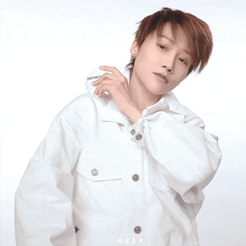 A Woman In A White Shirt Is Holding A Christian Dior Container GIF