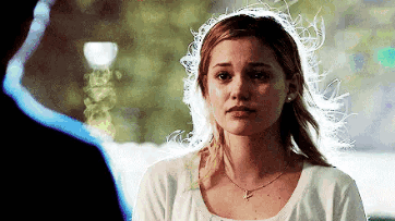 A Woman In A White Shirt Is Looking At A Man . GIF
