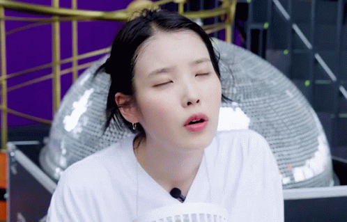 A Woman In A White Shirt Is Making A Face With Her Eyes Closed GIF
