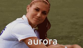 A Woman In A White Shirt With The Word Aurora On The Front GIF
