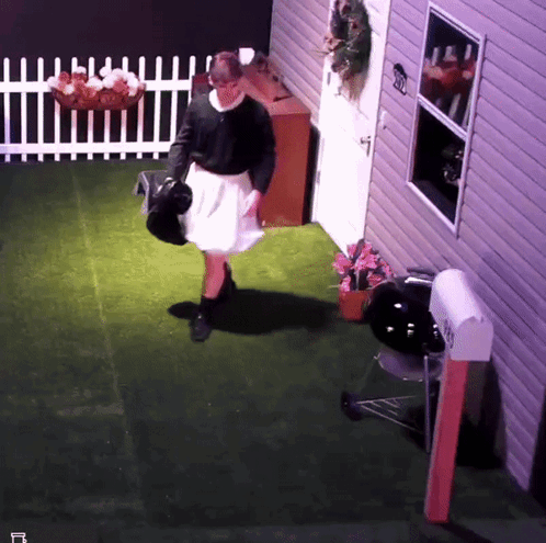 A Woman In A White Skirt Is Standing In Front Of A House With A Mailbox That Says ' Envelope ' On It GIF