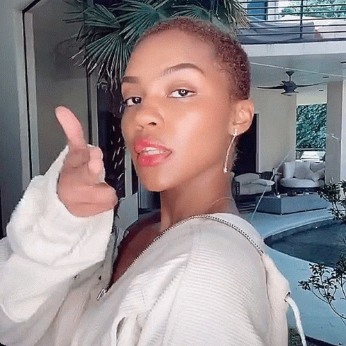 A Woman In A White Sweater Giving A Thumbs Up Sign GIF