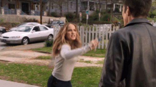 A Woman In A White Sweater Is Fighting A Man In A Black Jacket GIF