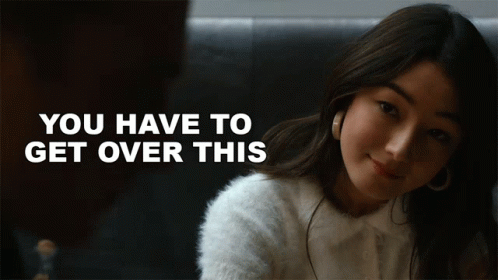 A Woman In A White Sweater With The Words " You Have To Get Over This " Behind Her GIF