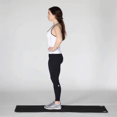 A Woman In A White Tank Top And Black Leggings Is Doing A Single Leg Squat On A Yoga Mat . GIF