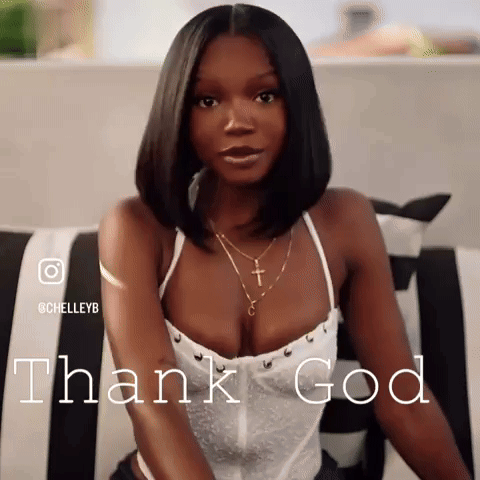 A Woman In A White Top Is Sitting On A Couch And The Words Thank God Are Behind Her GIF