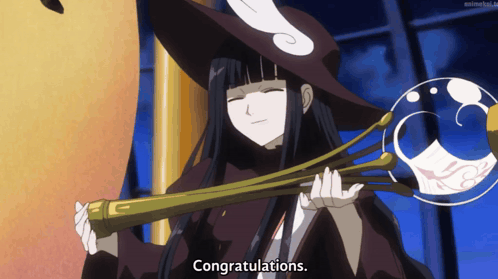 A Woman In A Witch Costume Holds A Wand And Says Congratulations GIF