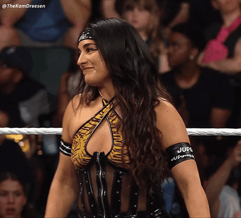 A Woman In A Wrestling Ring Has A Band Around Her Arm That Says Judge Judy GIF