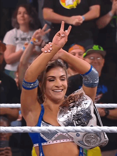 a woman in a wrestling ring holds a l2 championship belt