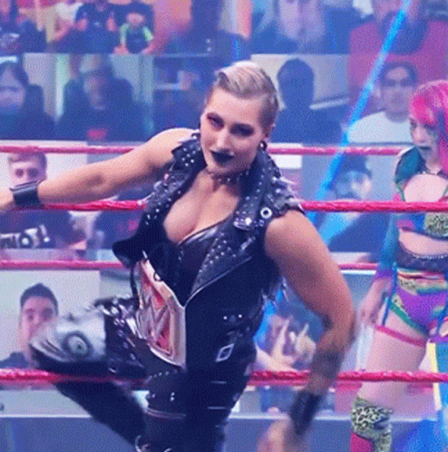 A Woman In A Wrestling Ring Is Wearing A Belt That Says ' Wwe ' On It GIF