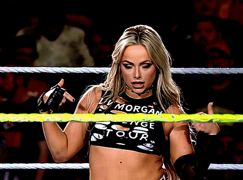 A Woman In A Wrestling Ring Wearing A Top That Says Morgan GIF