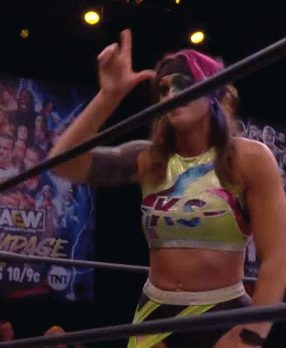 A Woman In A Wrestling Ring With A Sign That Says Aew GIF