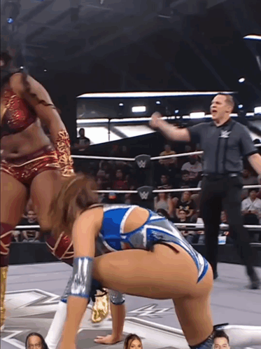 a woman in a wrestling ring with a w logo on the wall