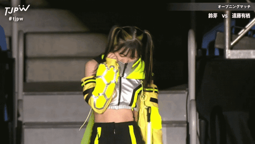 a woman in a yellow and black outfit with the letters tjpw on the top