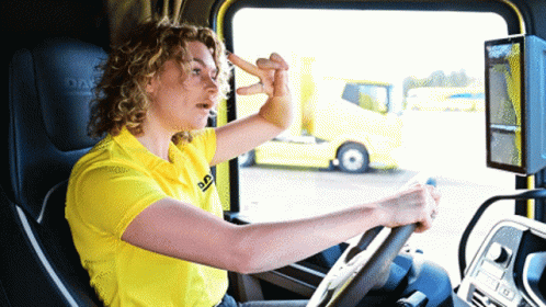 A Woman In A Yellow Daf Shirt Driving A Truck GIF