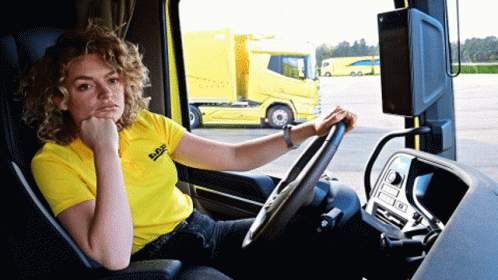 A Woman In A Yellow Daf Shirt Sits In A Truck GIF