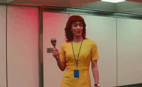 a woman in a yellow dress is holding a maraca in her hand