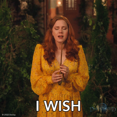 A Woman In A Yellow Dress Is Holding A Wand And The Words I Wish Are Above Her GIF