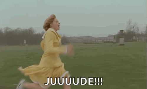 A Woman In A Yellow Dress Is Running In A Field And Saying Juuuuuude . GIF