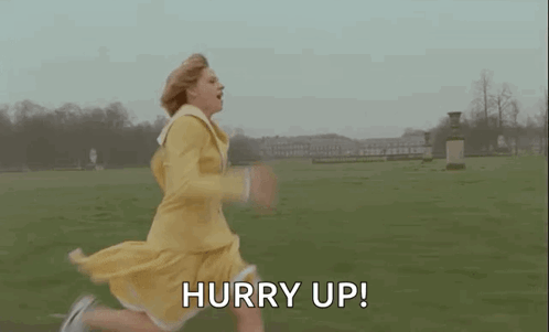 A Woman In A Yellow Dress Is Running In A Field With The Words Hurry Up . GIF
