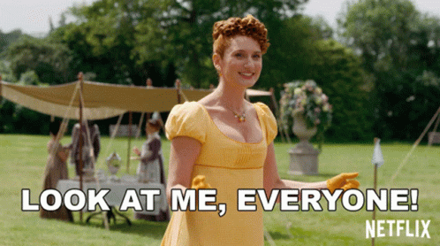 A Woman In A Yellow Dress Is Standing In A Field And Says Look At Me Everyone Netflix GIF