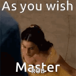 A Woman In A Yellow Dress Is Standing Next To A Man In A Blue Shirt And Says `` As You Wish Master Rob '' . GIF