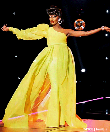 Woman In Yellow Dress On Stage With Arms Out GIF