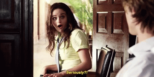 A Woman In A Yellow Shirt And Tie Is Talking To A Man . GIF
