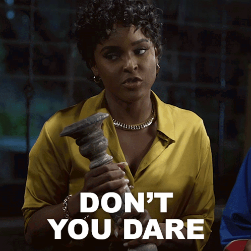 A Woman In A Yellow Shirt Is Holding A Candle Holder And Says " Don 'T You Dare " GIF