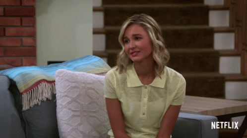 Woman In Yellow Shirt Sitting On Couch With Netflix GIF