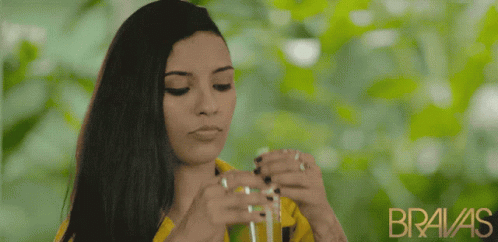 A Woman In A Yellow Shirt With The Word Bravas On The Bottom GIF