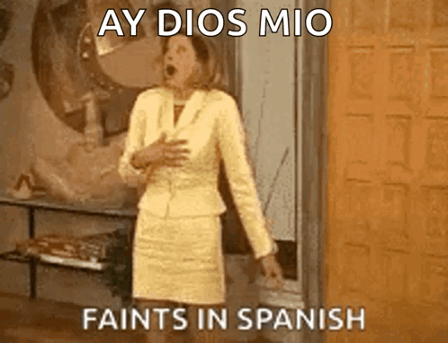 A Woman In A Yellow Suit Is Standing In Front Of A Door With Her Mouth Open And The Words Ay Dios Mio Faints In Spanish GIF