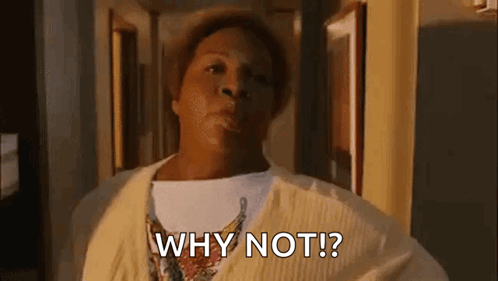 A Woman In A Yellow Sweater Is Standing In A Hallway And Saying `` Why Not ? '' GIF