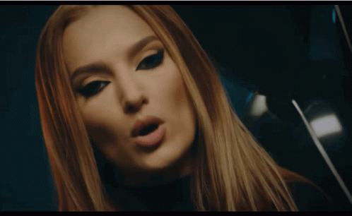 A Woman In A Zebra Print Shirt Touches A Large Screen GIF
