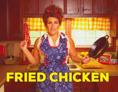 A Woman In An Apron Is Holding A Frying Pan In A Kitchen With The Words Fried Chicken Written In Yellow GIF