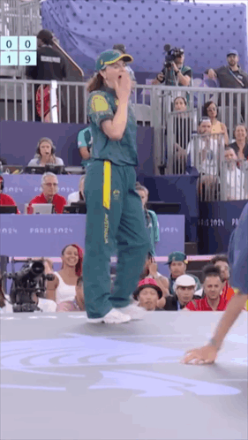 A Woman In An Australia Uniform Stands In Front Of A Crowd Of People GIF