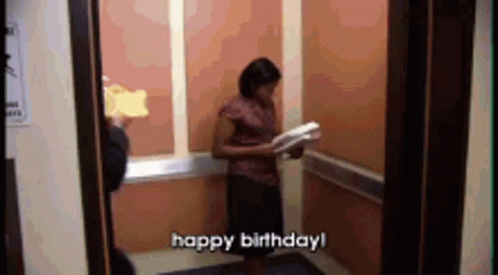 A Woman In An Elevator Is Holding A Piece Of Cake And Says Happy Birthday ! GIF