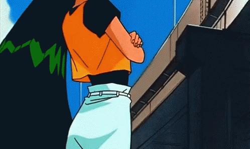 A Woman In An Orange Shirt And White Skirt Stands In Front Of A Building GIF