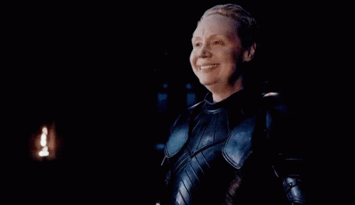 a woman in armor is smiling with her eyes closed .