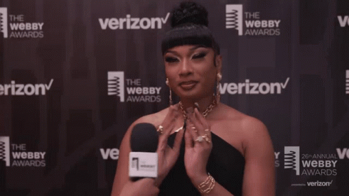 A Woman In Front Of A Wall That Says Verizon On It GIF