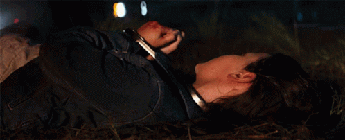 A Woman In Handcuffs Laying On The Ground GIF