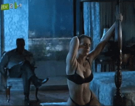 A Woman In Lingerie Is Dancing In Front Of A Man In A Chair With Itv 2 On The Bottom Right Corner GIF