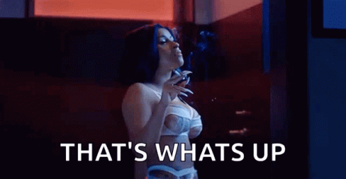 A Woman In Lingerie Is Smoking A Cigarette In A Dark Room . GIF