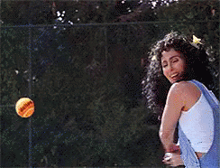 A Woman In Overalls Is Holding A Tennis Ball In Her Hand GIF