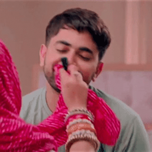 A Woman Is Applying Makeup To A Man 'S Face With A Brush . GIF