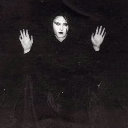 A Woman Is Behind Bars In A Jail Cell With Her Hands Behind The Bars . GIF