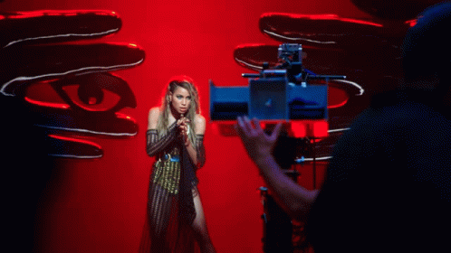 A Woman Is Being Filmed In Front Of A Camera GIF