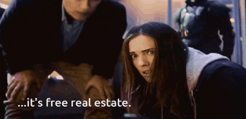 A Woman Is Being Held By A Man And Says It 'S Free Real Estate . GIF