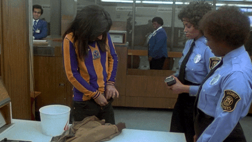 A Woman Is Being Searched By A Security Guard GIF