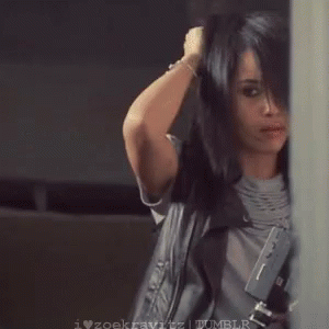 A Woman Is Blow Drying Her Hair While Holding A Hair Dryer In Her Hand . GIF
